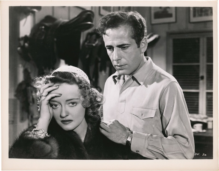 Judith (Bette Davis) is consoled by her stablemaster Michael O'Leary (Humphrey Bogart).