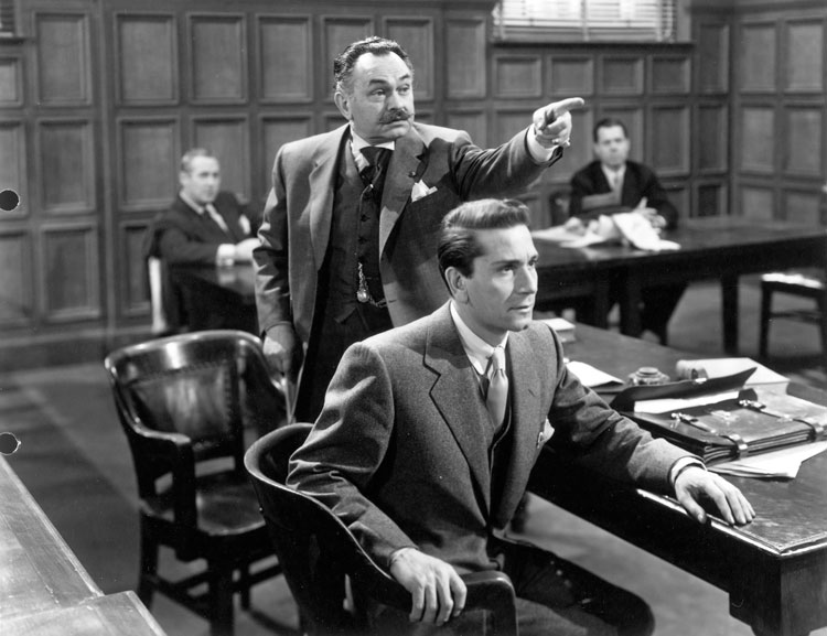 Banker Gino Monetti (Edward G. Robinson) makes a point as his lawyer son Max (Richard Conte) attends.