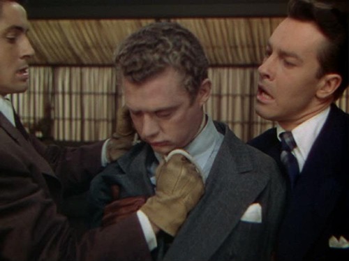 Phillip (Farley Granger) dispenses with former classmate David Kentley (Dick Hogan), while he is held by roomate and co-host Brandon (John Dall).